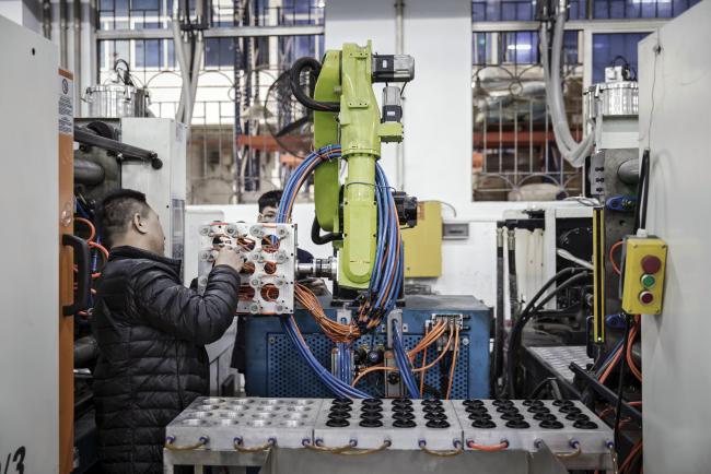 © Bloomberg. A technician adjusts an industrial robot manufactured by the E-Deodar Robot Equipment Co., a wholly-owned subsidiary of Ningbo Techmation Co., as it stands on the production line of Guangdong Shiyi Furniture Co. in Foshan, China, on Tuesday, Feb. 28, 2017. Photographer: Qilai Shen/Bloomberg