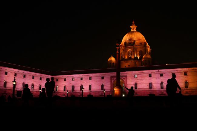 © Bloomberg. People are silhouetted as the North Block of the Central Secretariat buildings, which houses the Ministries of Finance and Home Affairs, stands illuminated at night in New Delhi, India, on Sunday, Jan. 28, 2018. With India's Finance Minister Arun Jaitley readying to deliver his annual budget on Feb. 1, traders are seeking to hedge a rally that has added more than $425 billion in equity values in the past four months. 