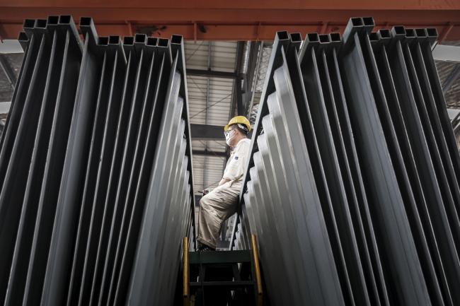 © Bloomberg. A worker sits on panels for shipping containers in the welding shop at the Singamas Container Holdings Ltd. factory in Qidong, China, on Thursday, June 22, 2017. As part of their pledge to cut emissions by 70 percent by the end of this year, manufacturers are coating containers with water-borne paints that release less toxic fumes than oil-based varieties before China starts levying a green tax in January 2018. Photographer: Qilai Shen/Bloomberg