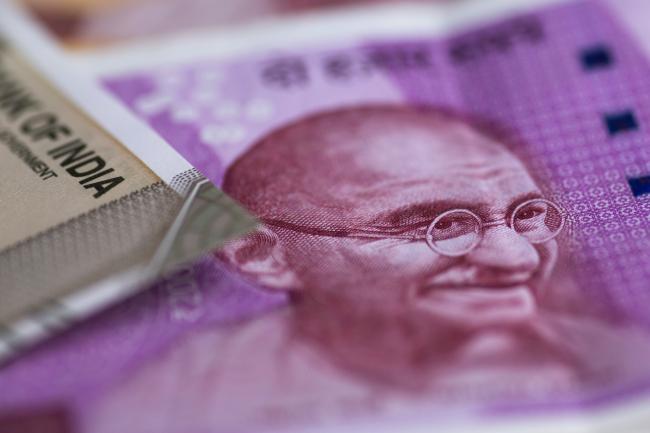© Bloomberg. The portrait of Mahatma Gandhi is displayed on an Indian 2,000 rupee banknote in an arranged photograph in Bangkok, Thailand, on Wednesday, Sept. 12, 2018. India's rupee dropped to a record low before trimming last week's loss; the government unveiled measures to prop up the sagging currency, including steps to facilitate bond issuance by local companies and possible curbs on imports. Photographer: Brent Lewin/Bloomberg