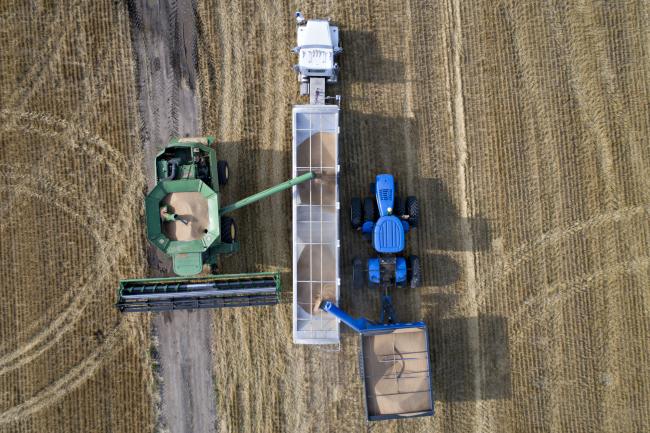 © Bloomberg. Hard red winter wheat is unloaded from a combine harvester in this aerial photograph taken above Kansas, U.S. Photographer: Bloomberg Creative Photos/Bloomberg