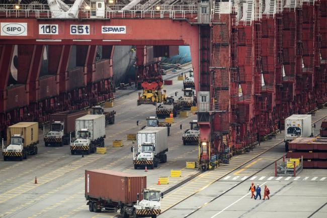© Bloomberg. Vehicles travel under gantry cranes at the Yangshan Deepwater Port, operated by Shanghai International Port Group Co. (SIPG), in Shanghai, China, on Friday, May 10, 2019.  Photographer: Qilai Shen/Bloomberg
