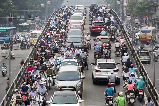 © Bloomberg. Vehicles and motorists travel along an overpass in Hanoi, Vietnam, on Tuesday, Sept. 11, 2018. The nation of 96 million people has embraced free-market reforms over the past few decades, leading to surging growth under an authoritarian one-party Communist government that offers the same political stability as China. Photographer: Maika Elan/Bloomberg