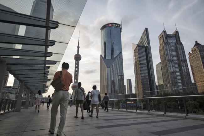 © Bloomberg. Pedestrians walk along an elevated walkway in the Lujiazui Financial District in Shanghai, China, on Monday, Sept. 4, 2017. The Chinese central bank's tight leash on liquidity is straining the bond market, with the benchmark sovereign yield climbing to near the highest level since April 2015. Photographer: Qilai Shen/Bloomberg