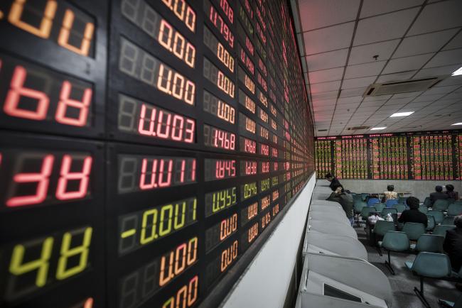 © Bloomberg. Investors stand at trading terminals in front of an electronic stock board at a securities brokerage in Shanghai, China, on Wednesday, Nov. 9, 2016. Global markets were thrown into disarray as early results from the U.S. election raised the possibility that Donald Trump may prevail over Hillary Clinton in the race for the presidency, shocking traders who had focused on polls in recent days showing the opposite. Photographer: Qilai Shen/Bloomberg