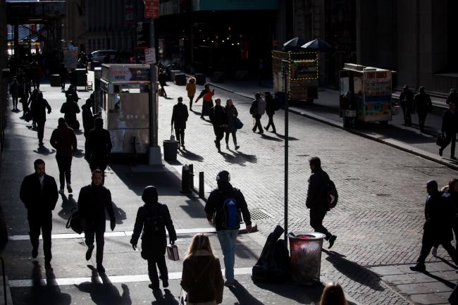 © Bloomberg. Pedestrians walk along Wall Street near the New York Stock Exchange (NYSE) in New York, U.S., on Monday, March 5, 2018. U.S. stocks turned higher and Treasuries erased gains as investors speculated that President Donald Trump's tough tariff talk won't translate into the most severe protectionist policies.