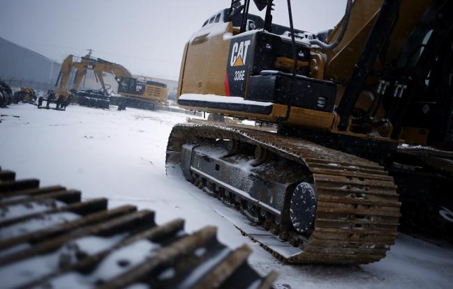 © Bloomberg. A Caterpillar Inc. 336E excavator is displayed for sale in the snow at Whayne Supply Company in Lexington, Kentucky. 