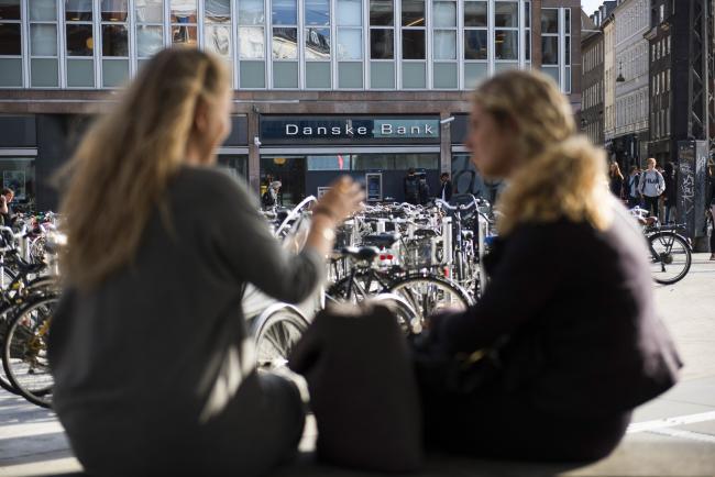© Bloomberg. Pedestrians converse near a bike parking space outside a Danske Bank A/S bank branch in central Copenhagen, Denmark, on Wednesday, Sept. 19, 2018. Danske Bank A/S Chief Executive Officer Thomas Borgen will step down amid allegations his bank was at the center of a major European money laundering scandal with as much as $234 billion flowing through a tiny unit in Estonia. 