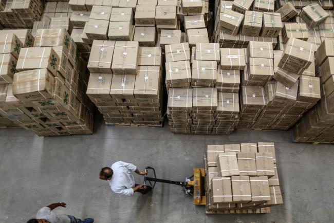 © Bloomberg. An employee pulls a pallet loaded with boxes inside a warehouse operated by Patanjali Ayurved Ltd. near to the Multi-modal International Cargo Hub Airport at Nagpur (MIHAN) in Nagpur, India, on Friday, April 28, 2017. India is on the cusp of a sweeping tax overhaul that could turn Nagpur, at the crossroads of busy road and rail corridors that bisect India east to west and north to south, into one of the nation's biggest logistics hubs. Photographer: Dhiraj Singh/Bloomberg