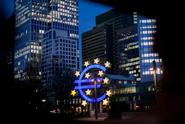 © Bloomberg. The euro sign sculpture stands illuminated near the former European Central Bank (ECB) headquarters at dusk in Frankfurt, Germany.