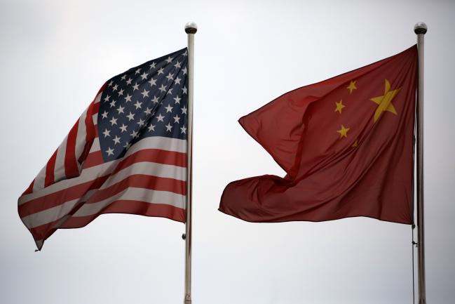 © Bloomberg. U.S. and Chinese national flags fly outside a company building in the China (Shanghai) Pilot Free Trade Zone's Waigaoqiao free trade zone and logistics park in Shanghai, China. Photographer: Tomohiro Ohsumi/Bloomberg