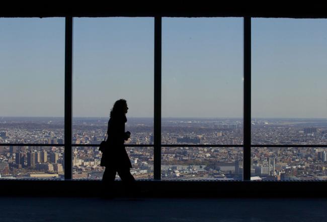 © Bloomberg. The silhouette of a member of the media is seen touring the 68th floor after the 4 World Trade Center dedication ceremony in New York, U.S. Photographer: Jin Lee/Bloomberg