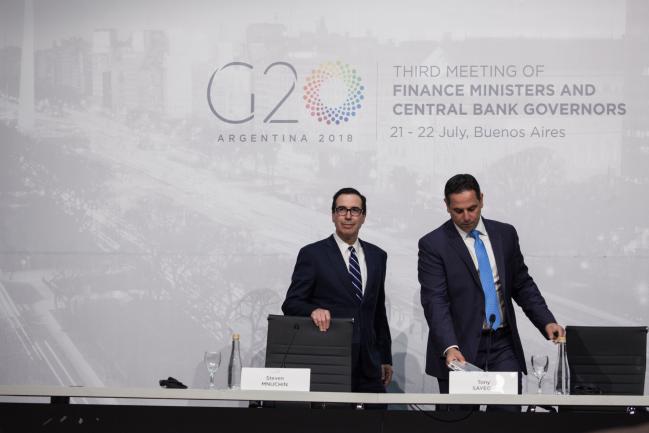 © Bloomberg. Steven Mnuchin, U.S. Treasury secretary, left, and Tony Sayegh, spokesman for the U.S. Treasury Department, arrive at a news conference during the G-20 finance ministers and central bankers meetings in Buenos Aires, Argentina, on Sunday, July 22, 2018. Mnuchin said that there is no chance of a currency war erupting despite U.S. President Donald Trump tweets. Photographer: Erica Canepa/Bloomberg 
        