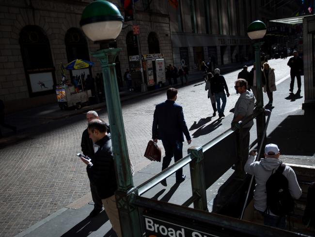 © Bloomberg. Pedestrians walk along Wall Street near the New York Stock Exchange. Photographer: Michael Nagle/Bloomberg