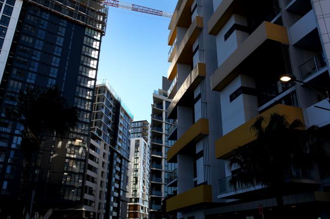 © Bloomberg. Newly constructed apartment blocks stand in the suburb of Wolli Creek in Sydney, Australia, on Sunday, June 17, 2018. Australia is riding out a huge gamble on property. The bet: 27 years of recession-free economic growth—during which Sydney home prices surged fivefold—would continue unabated and allow borrowers to keep servicing their debt. Photographer: Lisa Maree Williams/Bloomberg