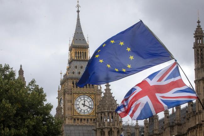 © Bloomberg. An anti-Brexit demonstrator waves a Union flag, also known as a Union Jack, with an European Union (EU) flag outside the Houses of Parliament in London, U.K., on Tuesday, Sept. 5, 2017.