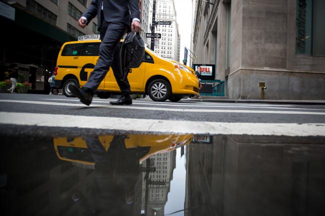 © Bloomberg. A man walks along Wall Street as a taxi turns a corner near the New York Stock Exchange (NYSE) in New York, U.S., on Monday, June 11, 2018. U.S. equities crept higher while European stocks rose as investors eased into a hectic week during which three major central banks set interest rates, President Donald Trump meets North Korea's leader and Brexit returns to the fore. Photographer: Michael Nagle/Bloomberg