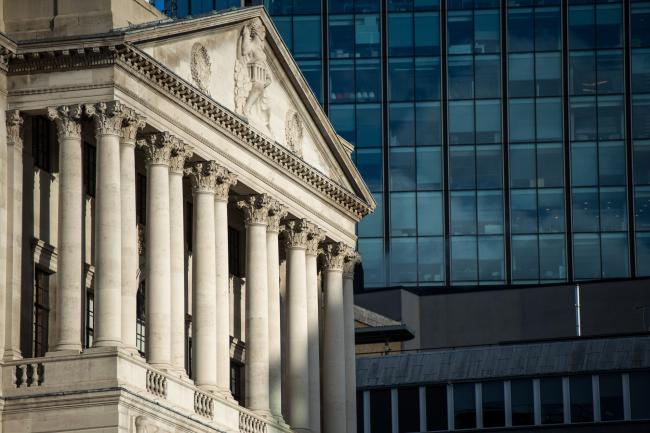 © Bloomberg. The Bank of England (BoE) stands near to an office building in the City of London, U.K., on Friday, Dec. 15, 2017. Bank of England policy makers said the breakthrough in Brexit negotiations this month could prove to be positive for the U.K. economy, which has lagged behind many of its international peers this year.