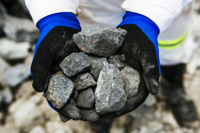 © Bloomberg. A worker holds rocks of raw platinum ore for a photograph at the Northam Platinum Ltd. Booysendal platinum mine, located outside the town of Lydenburg in Mpumalanga, South Africa, on Tuesday, Jan. 23, 2018. Booysendal will use a system developed by an Austrian company that builds ski lifts to transport the ore up a 30 degree incline out of a valley for processing, instead of the traditional conveyer used throughout South Africa or the more expensive option of trucking. Photographer: Waldo Swiegers/Bloomberg