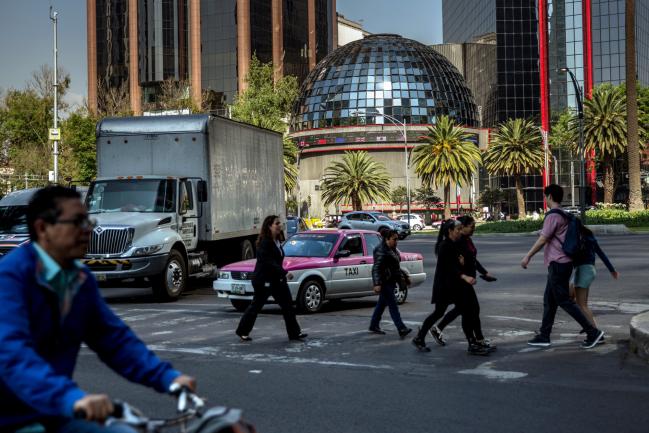 © Bloomberg. Pedestrians pass in front of the Bolsa Mexicana de Valores SAB, Mexico's stock exchange, in Mexico City, Mexico, on Friday, Feb. 15, 2018. The National Institute of Statistics and Geography (INEGI) is scheduled to release gross domestic product (GDP) figures on February 23.