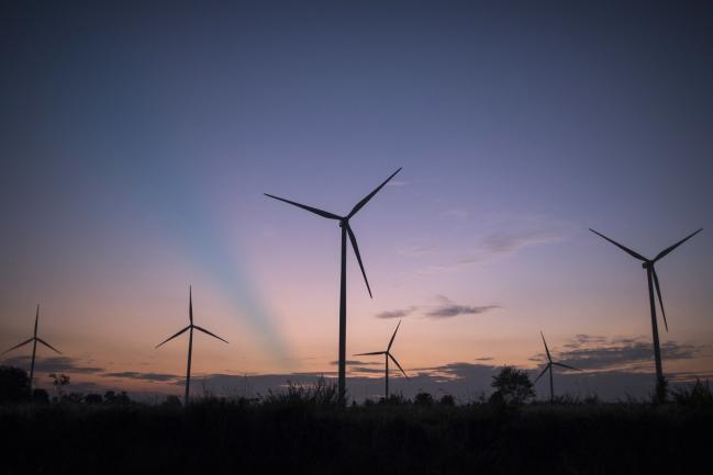© Bloomberg. Wind turbines stand at the Subplu wind farm solar farm, operated by Gunkul Engineering Pcl., at dusk in Huay Bong, Thailand, on Thursday, Nov. 2, 2017. Gunkul, the most expensive energy stock in Thailand, plans to invest more than 20 billion baht ($599 million) in Japanese solar projects to boost earnings growth. Photographer: Brent Lewin/Bloomberg