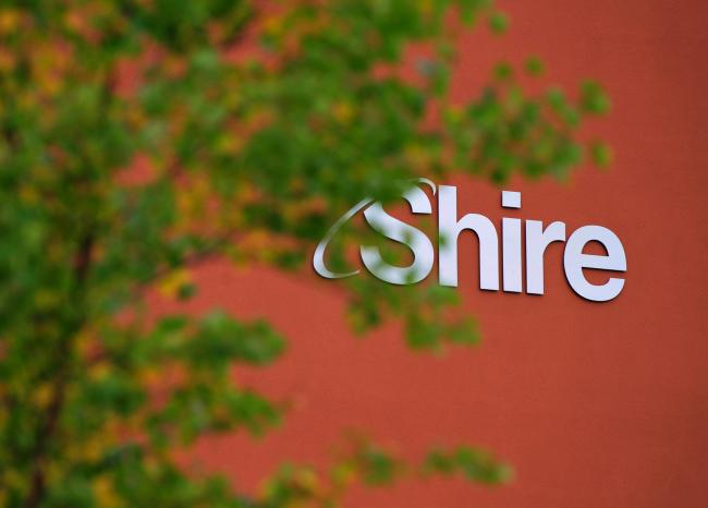 © Bloomberg. A Shire Plc logo sits on a wall outside the company's offices at the Citywest Business Campus in Dublin, Ireland. Photographer: Aidan Crawley/Bloomberg