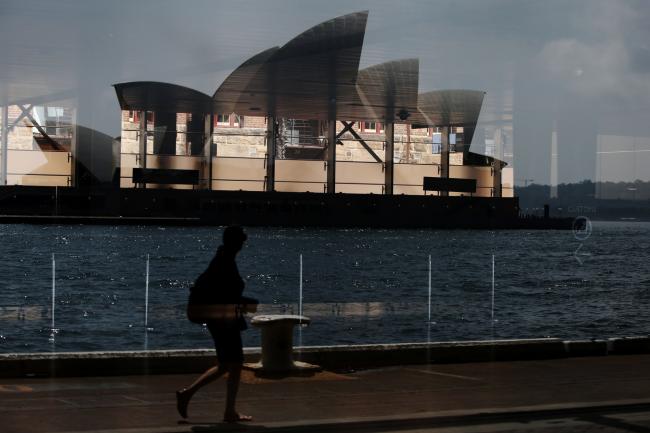 © Bloomberg. A pedestrian and the Sydney Opera House are reflected in a window in Sydney, Australia, on Friday, Jan. 11, 2019. Australian consumer confidence slumped the most in more than three years, amid pessimism over falling property prices and economic growth, after the nation's dollar tumbled to the weakest in almost 10 years at the beginning of the month. Photographer: Lisa Maree Williams/Bloomberg