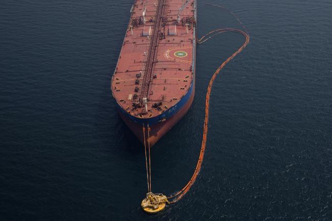 © Bloomberg. Pipes feed crude oil to the 'Xin Run Yang' oil tanker, operated by Cosco Shipping Holdings Co., during loading operations near the Ras Tanura oil refinery, in Res Tanura, Saudi Arabia. Photographer: Simon Dawson/Bloomberg