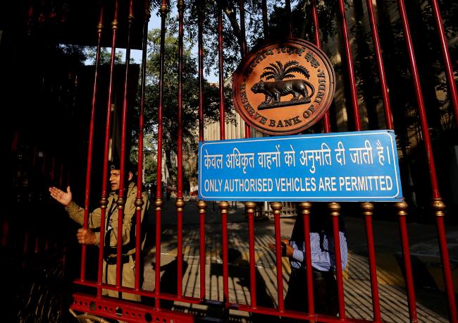 © Bloomberg. A security guard stands at the gate of the Reserve Bank of India (RBI) headquarters in New Delhi, India.