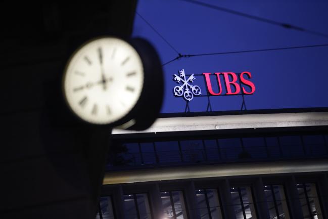 © Bloomberg. A sign sits illuminated on the roof of the UBS Group AG headquarters in Zurich, Switzerland, on Monday, May 2, 2016. UBS said first-quarter profit plunged 64 percent, missing analyst estimates, as market turbulence eroded earnings at the wealth-management and securities units. 