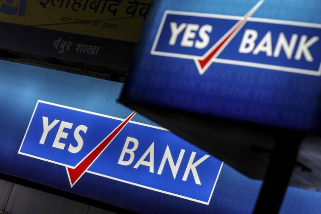 © Bloomberg. Signage for Yes Bank Ltd. is displayed at a branch in Mumbai, India, on Tuesday, April 30, 2018. Shares of Yes Bank slumped 29 percent on Tuesday, its biggest decline on record after the lender headed by newly appointed Chief Executive Officer Ravneet Gill reported a surprise quarterly loss. 