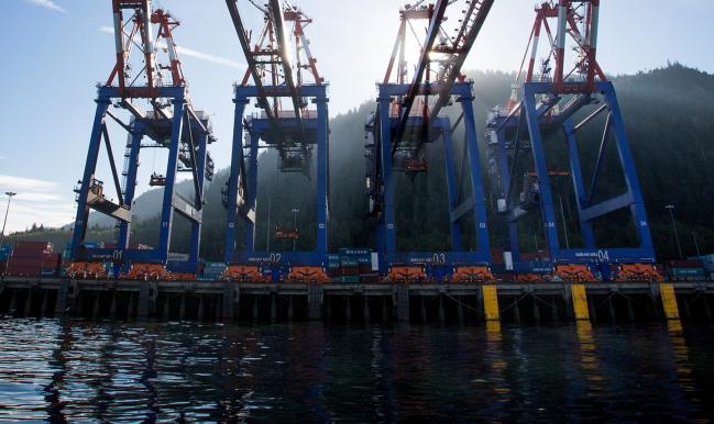 © Bloomberg. Container cranes stand at the Fairview Container terminal of the Port of Prince Rupert in Prince Rupert, British Columbia, Canada, on Tuesday, Aug. 23, 2016. Facing five major energy initiatives in B.C., Canadian Prime Minister Trudeau will choose which constituency to abandon. He's allowed a hydroelectric dam to proceed; pending are decisions on Enbridge Inc.'s Northern Gateway crude pipeline, Petroliam Nasional Bhd.'s LNG project on Lelu Island, a pipeline expansion by Kinder Morgan Inc., as well as a ban on crude oil tankers.