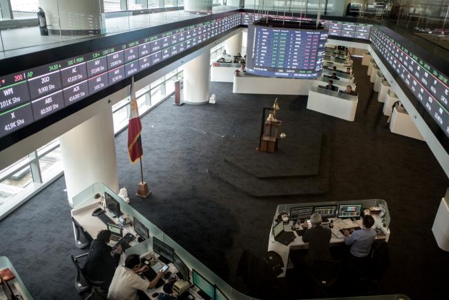 © Bloomberg. Traders work beneath a monitor and an electronic ticker at the trading floor of the Philippine Stock Exchange in Bonifacio Global City, Metro Manila, the Philippines. Photographer: Carlo Gabuco/Bloomberg