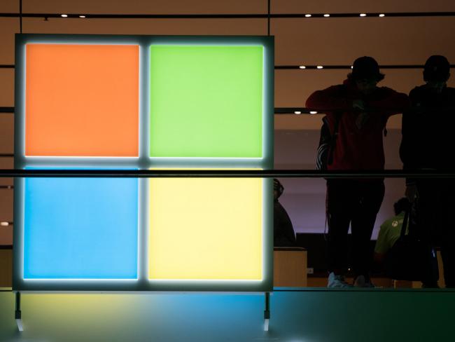 © Bloomberg. Customers stand near the Microsoft Corp. logo during the Microsoft Corp. Xbox One X game console global launch event in New York, U.S., on Monday, Nov. 6, 2017. As Microsoft Corp. begins selling a new Xbox console, the focus of its video-game unit is shifting toward software and services. The company plans to increase investment in developing in-house video games. Photographer: Bloomberg/Bloomberg