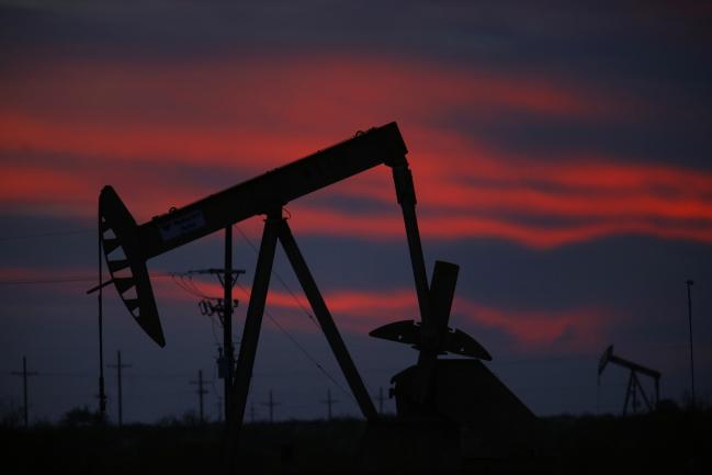 © Bloomberg. The silhouette of an electric oil pump jack is seen at dusk in the oil fields surrounding Midland, Texas, U.S., on Tuesday, Nov. 7, 2017. Nationwide gross oil refinery inputs will rise above 17 million barrels a day before the year ends, according to Energy Aspects, even amid a busy maintenance season and interruptions at plants in the U.S. Gulf of Mexico that were clobbered by Hurricane Harvey in the third quarter. Photographer: Luke Sharrett/Bloomberg