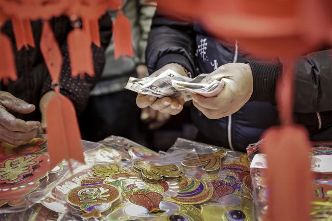 © Bloomberg. A man counts Chinese yuan banknotes at a shop selling ornaments ahead of the Lunar New Year in the Yuyuan district of Shanghai, China, on Sunday, Jan. 22, 2017. The People's Bank of China said Friday it extended a temporary liquidity facility to some major commercial banks for 28 days to help ease a cash crunch before the Lunar New Year holiday.