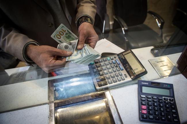 © Bloomberg. An employee counts out U.S. dollar banknotes at a currency exchange store on Ferdowsi street in Tehran, Iran, on Saturday, Jan. 6, 2018. A wave of bad loans from unregulated lenders has rocked the banking sector and oil prices have averaged less than $60 a barrel for the past three years, draining Iran of a key source of revenue. Photographer: Ali Mohammadi/Bloomberg