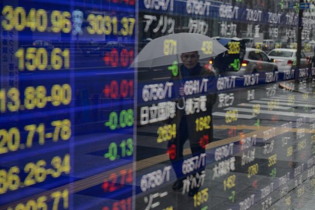 © Bloomberg. A pedestrian is reflected in an electronic stock board at a securities firm in Tokyo, Japan, on Monday, March 6, 2017. The Topix and U.S. stock futures were lower as Japan moved to the highest possible alert level after North Korea fired four ballistic missiles into nearby waters. 