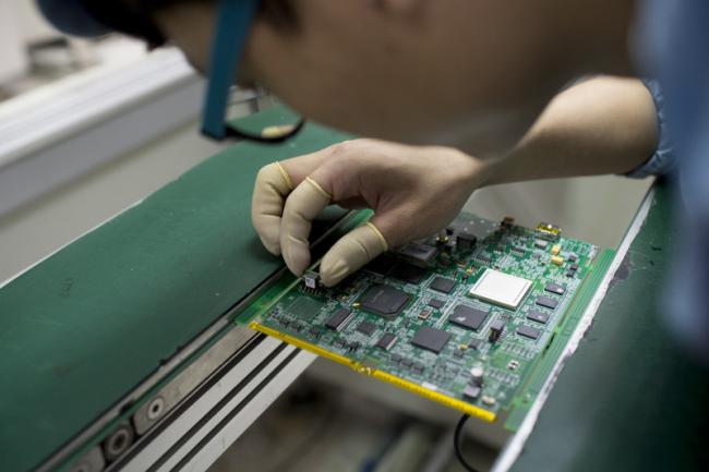 © Bloomberg. An employee places a connector on a circuit board in a manufacturing facility at ZTE Corp.'s headquarters in the Nanshan district of Shenzhen, China, on Thursday, Aug. 7, 2014. ZTE, a Chinese maker of telecommunications equipment and systems, is scheduled to report second quarter earnings on Aug. 20. Photographer: Brent Lewin/Bloomberg