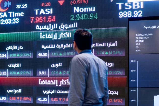 © Bloomberg. A visitor looks at stock price information displayed on a digital screen inside the Saudi Stock Exchange, also known as the Tadawul, in Riyadh, Saudi Arabia, on Tuesday, April 10, 2018. Foreign investors bought more Saudi stocks in March than ever before in anticipation of the kingdom’s upgrade to emerging-market status. Photographer: Abdulrahman Abdullah/Bloomberg