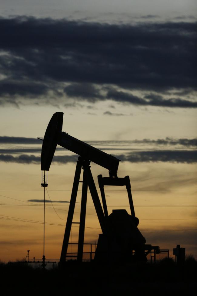 © Bloomberg. The silhouette of an electric oil pump jack is seen at dusk in the oil fields surrounding Midland, Texas, U.S., on Tuesday, Nov. 7, 2017. Nationwide gross oil refinery inputs will rise above 17 million barrels a day before the year ends, according to Energy Aspects, even amid a busy maintenance season and interruptions at plants in the U.S. Gulf of Mexico that were clobbered by Hurricane Harvey in the third quarter.