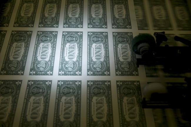 © Bloomberg. 50 subject one dollar note sheets are run through an intaglio printing press before the face is printed at the U.S. Bureau of Engraving and Printing in Washington, D.C., U.S. Photographer: Andrew Harrer/Bloomberg