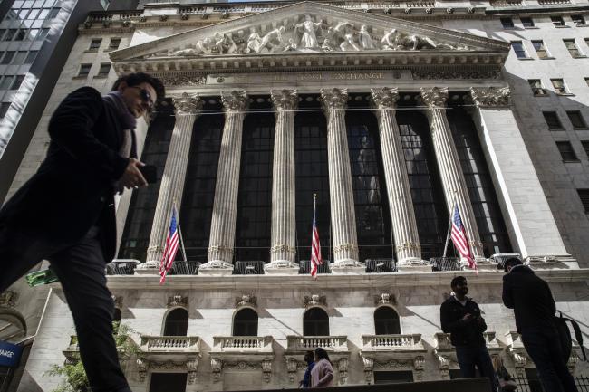 © Bloomberg. Pedestrians walk on Wall Street in front of the New York Stock Exchange (NYSE) in New York, U.S., on Friday, Oct. 19, 2018. The rebound in U.S. stocks lost steam as investors assessed the latest batch of corporate earnings and simmering geopolitical tensions ahead of the weekend. Photographer: Victor J. Blue/Bloomberg