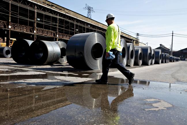 © Bloomberg. A worker walks past steel coils at the U.S. Steel Corp. Granite City Works facility in Granite City, Illinois, U.S., on Thursday, July 26, 2018. U.S. President Donald Trump celebrated U.S. Steel Corp's decision to re-employ hundreds of laid-off workers and lamented decades of past leaders' trade policies. Photographer: Daniel Acker/Bloomberg