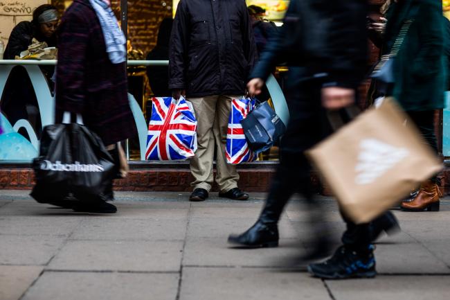 © Bloomberg. A pedestrian holds shopping bags branded with the Union Flag, also know as Union Jack, on Oxford Street in central London, U.K., on Tuesday, Dec. 4, 2018. U.K. consumer spending growth slowed in November as concerns about Brexit prompted households to become more cautious with their cash. 