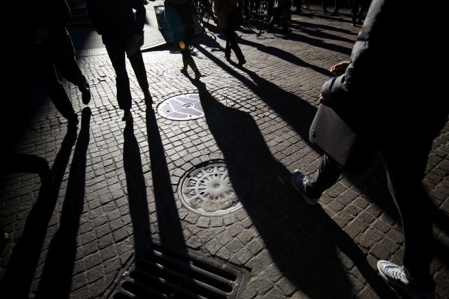 © Bloomberg. Pedestrians walk along Wall Street near the New York Stock Exchange (NYSE) in New York, U.S. 