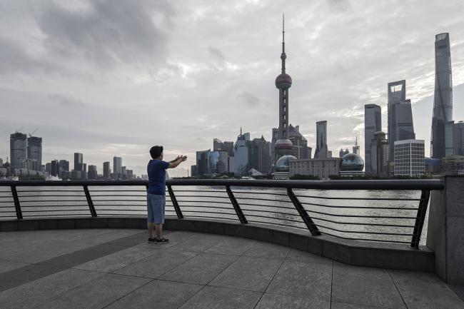 © Bloomberg. A woman exercising on the bund looks across the Huangpu River to the Lujiazui Financial District in Shanghai, China, on Monday, Sept. 4, 2017. The Chinese central bank's tight leash on liquidity is straining the bond market, with the benchmark sovereign yield climbing to near the highest level since April 2015.