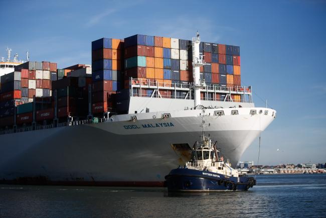 © Bloomberg. A tugboat guides the Orient Overseas Container Line's (OOCL) Malaysia container ship, into dock after arriving at the container terminal operated by DP World Ltd., at the Port of Southampton, in Southampton, U.K., on Wednesday, Nov. 2, 2016. Export optimism in the U.K. has risen to the highest in two-and-a-half years thanks to the pound's depreciation since the Brexit vote, according to the Confederation of British Industry. 