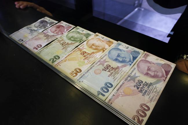 © Bloomberg. Turkish lira banknotes sit in this arranged photograph at a currency exchange in Istanbul, Turkey, on Friday, March 16, 2018. As Turkish markets tumble, investor attention is turning once more to the central bank for signs it’s willing to backstop the nation’s assets.