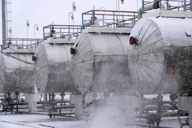 © Bloomberg. Snow falls as steam rises from pipes near gas cylinders at the oil and gas field processing and drilling site operated by Ukrnafta PJSC in Gnidyntsi, Chernihiv region, Ukraine, on Tuesday, Nov. 29, 2016. Optimism OPEC ministers in Vienna will salvage a deal to cut production reverberated through the financial markets, spurring oil's biggest gain in two weeks and sending stocks of energy producers and currencies of commodity-exporting nations higher. Photographer: Vincent Mundy/Bloomberg